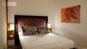 a bedroom with a king sized bed with a dragon painting on the wall at Cascina Vittoria Restaurant Lab & Rooms in Rognano