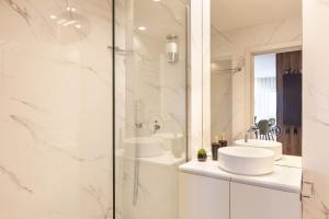 a white bathroom with two sinks and a shower at ALL4Braga - Minho's Guest in Braga +17 photos