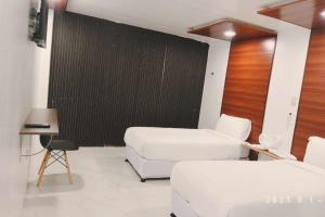 a room with two beds and a black wall at Mbs Hotel (Maramag Business Suites) in Maramag
