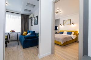 ein Schlafzimmer mit einem Bett und einem blauen Sofa in der Unterkunft MYFREEDOM Апартаменти Залізничний Вокзал in Kiew