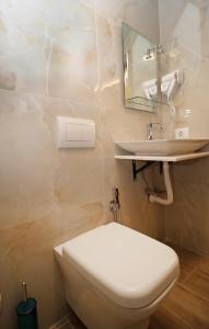 y baño con aseo blanco y lavamanos. en Vila Fatos Qama en Berat