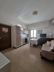 eine Küche und ein Wohnzimmer mit einem Sofa und einem Tisch in der Unterkunft Caruso Apartment in Marina di Schiavonea