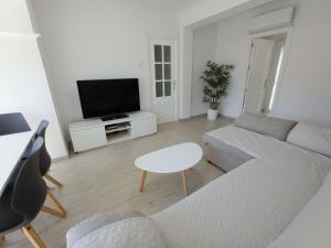 a living room with a couch and a tv at Gades Natura Apartment a 450 mts Victoria beach in Cádiz