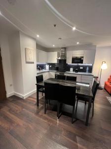 a kitchen and dining room with a table and chairs at Spacious Sleep 8 Flat 20 mins Central London BP9 in London