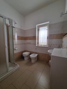 ein Badezimmer mit einem WC, einer Badewanne und einem Waschbecken in der Unterkunft Caruso Apartment in Marina di Schiavonea