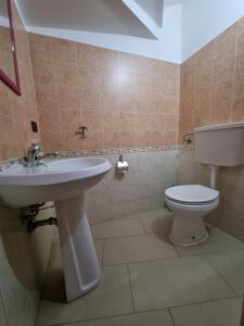 ein Bad mit einem Waschbecken und einem WC in der Unterkunft Caruso Apartment in Marina di Schiavonea