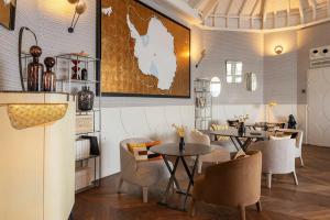 a restaurant with tables and chairs and a map on the wall at Castelbrac Hotel & Spa in Dinard