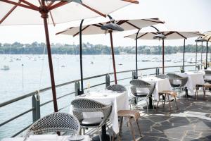 a restaurant with tables and chairs and the water at Castelbrac Hotel & Spa in Dinard