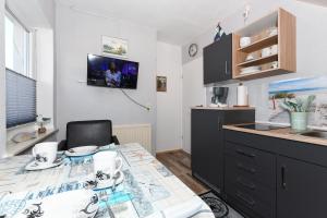 a kitchen with a table and a sink and a counter at Ferienwohnung Ankerplatz im Gästehaus Kock in Neuharlingersiel