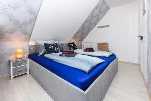 Un dormitorio con una cama grande con sábanas azules. en Ferienwohnung Ankerplatz im Gästehaus Kock, en Neuharlingersiel
