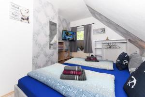 Un dormitorio con dos camas y un televisor. en Ferienwohnung Ankerplatz im Gästehaus Kock, en Neuharlingersiel