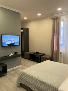 a bedroom with a bed and a flat screen tv at Haya Guest House in Kʼanakʼerravan