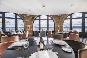 a restaurant with tables and chairs and windows at Castelbrac Hotel & Spa in Dinard