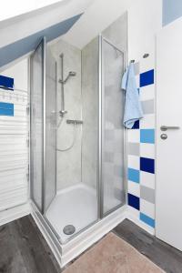 una ducha con puerta de cristal en un baño en Ferienwohnung Ankerplatz im Gästehaus Kock, en Neuharlingersiel