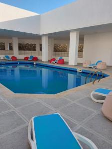 una grande piscina con sedie in un edificio di شاليه قرية قرطاج الساحل الشمالي a El Alamein