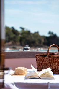 a straw hat and a book on a table with a basket at Castelbrac Hotel & Spa in Dinard