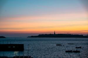 a sunset over a body of water with boats in it at Castelbrac Hotel & Spa in Dinard