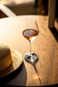 a glass of wine and a hat on a table at Castelbrac Hotel & Spa in Dinard