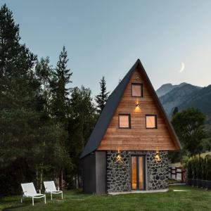 a house with two white chairs in front of it at Chalet Tir Longë in Cesana Torinese