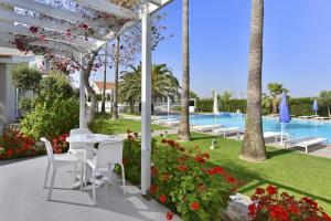 a patio with a table and chairs and a pool at Mon Repos Hotel in Ayia Napa