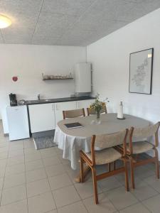 een keuken met een tafel en een aantal stoelen en een tafel en een keuken bij Vestervang bed and breakfast in Nykøbing Mors