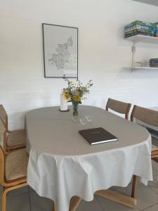 einen Tisch mit einem weißen Tischtuch und Blumen darauf in der Unterkunft Vestervang bed and breakfast in Nykøbing Mors