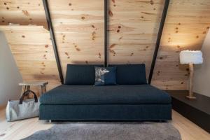 a blue couch in a room with a wooden wall at Chalet Tir Longë in Cesana Torinese