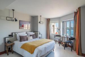 a bedroom with a bed and a table with chairs at Castelbrac Hotel & Spa in Dinard