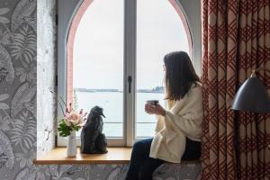 a woman looking out of a window at a dog at Castelbrac Hotel & Spa in Dinard