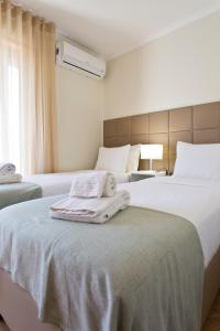 Studios Porto Solar في بورتو: غرفة في الفندق بسريرين يوجد مناشف على السرير