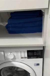 a washing machine with blue towels on top of it at Apartament Hebanowa in Swarzędz
