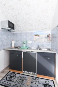 eine Küche mit einer Spüle und einer Arbeitsplatte in der Unterkunft Apartment Meeresrauschen im Gästehaus Kock in Neuharlingersiel