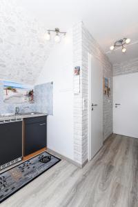 Apartment Meeresrauschen im Gästehaus Kock في نايهالينجازييل: مطبخ مع حوض وطاولة عمل