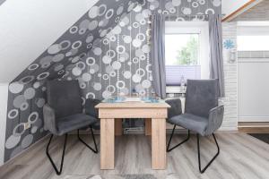 einen Tisch und zwei Stühle in einem Zimmer mit einer Wand in der Unterkunft Apartment Meeresrauschen im Gästehaus Kock in Neuharlingersiel