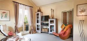 uma sala de estar com duas cadeiras e uma televisão em Ferienvilla Gaisser em Bad Hindelang