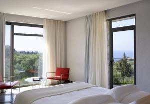 a bedroom with a bed and a large window at Leivatho Hotel in Svoronata