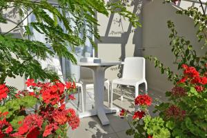 two white chairs and a table and some flowers at Mon Repos Hotel in Ayia Napa +23 photos