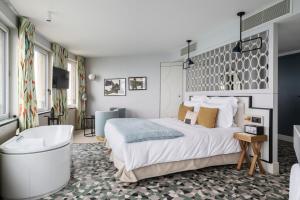 a bedroom with a large bed and a bath tub at Castelbrac Hotel & Spa in Dinard