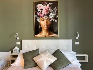 Una camera da letto con un ritratto di una donna con dei fiori in testa di Appartamenti Mar y Sol a Gabicce Mare