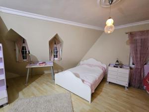 a bedroom with a bed and a desk and windows at Villa surrounded by nature in Kireçhane