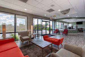 a waiting room with red furniture and windows at Ramada by Wyndham Altamonte Springs Near I-4 in Orlando