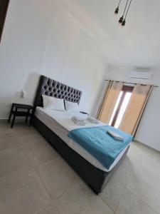 1 dormitorio con 1 cama grande y ventana grande en Skopelos House Nikols, en Loutraki