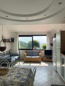 een woonkamer met een bank en een tafel en een keuken bij Casa Regina Porto Luna 1 Villasimius in Simius