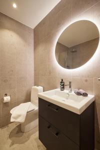 a bathroom with a sink and a toilet and a mirror at Barsebäck Resort Hotell in Löddeköpinge