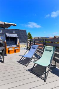 Apartment Meeresrauschen im Gästehaus Kock في نايهالينجازييل: كرسيين جالسين فوق السطح