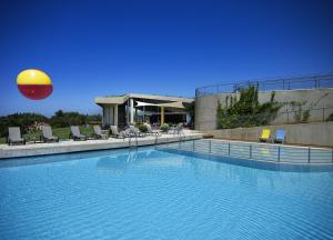 a large swimming pool with a beach ball in the air at Leivatho Hotel in Svoronata