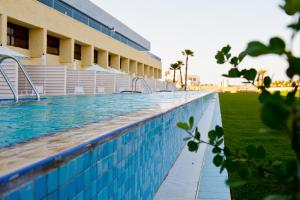 einem Pool vor einem Gebäude in der Unterkunft Herods Dead Sea – A Premium Collection by Fattal Hotels in Ein Bokek