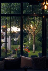 a couch in front of a window looking out at a garden at REDROOF country house hotel in Goris