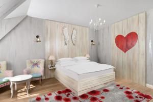a bedroom with a white bed and a red heart on the wall at Maison Bistro & Hotel in Budapest