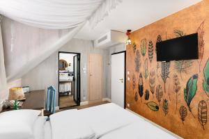 a bedroom with a bed and a tv on a wall at Maison Bistro & Hotel in Budapest